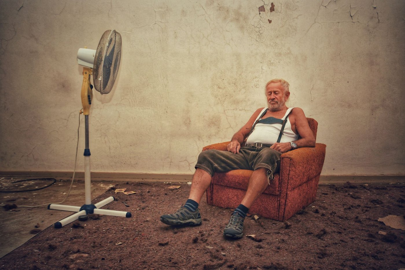 Un anciano se refresca ante un ventilador durante una ola de calor