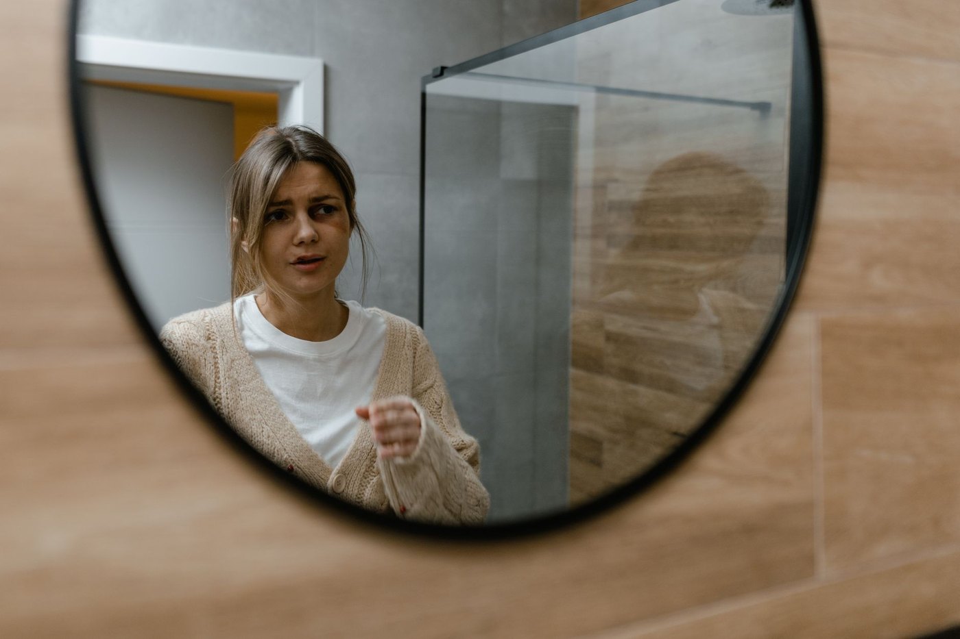 Mujer mirándose al espejo con gesto preocupado