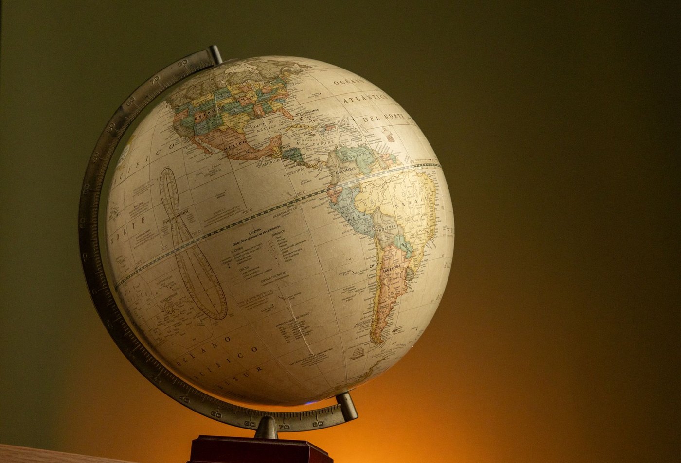 Globo terráqueo antiguo con los nombres de los países en español, iluminado con luz cálida