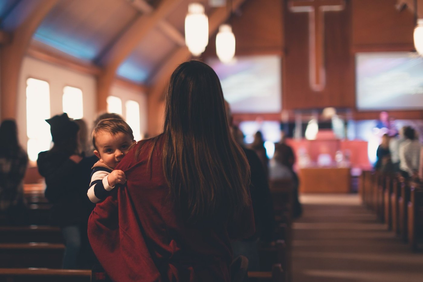 Una mujer con su beb&eacute; en brazos durante un culto