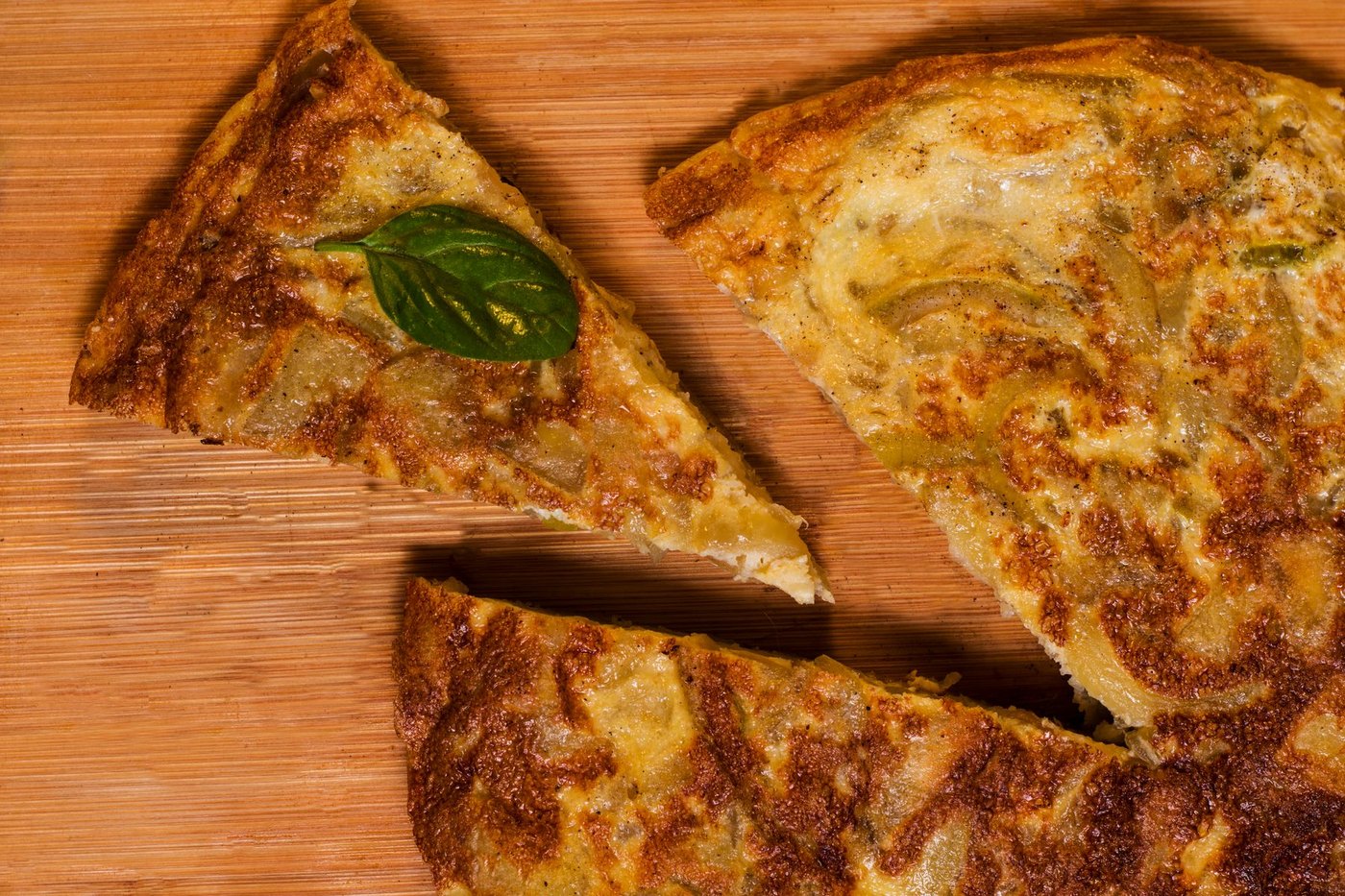 Tortilla de patatas cortada sobre una tabla de madera